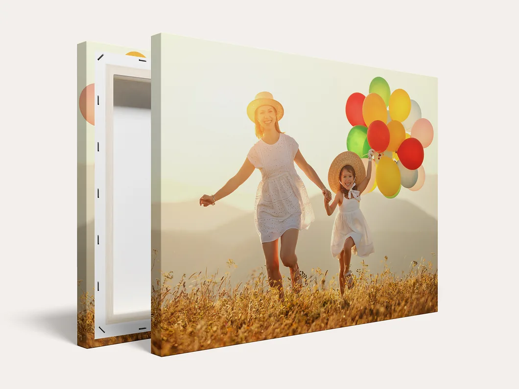 Canvas print of a mother and child with balloons in a sunlit field