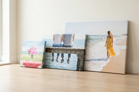 Three photo canvases in different sizes standing side by side against a wall, showing how the formats compare
