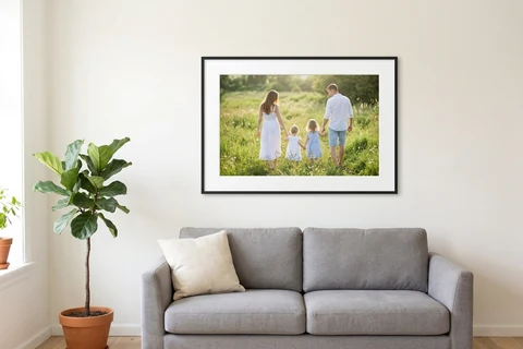 A family photograph in a black frame with a white mount, hung above a sofa