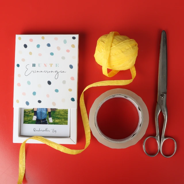 Für diesen DIY-Tipp benötigst du nur: eine Schere, Klebeband und deine Retrofotos.
