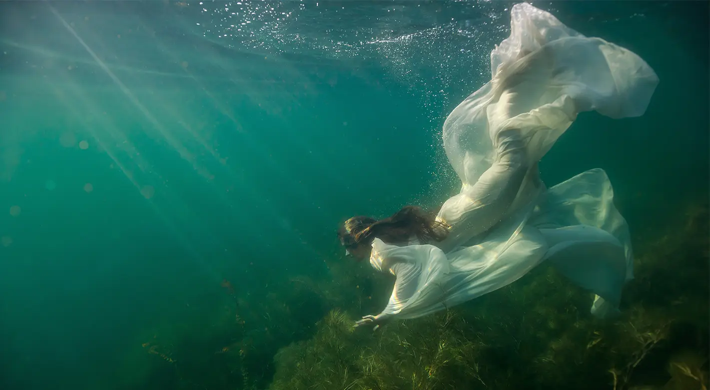 Eine Schnorchlerin fotografiert unter Wasser – Unterwasserfotografie für Einsteiger.