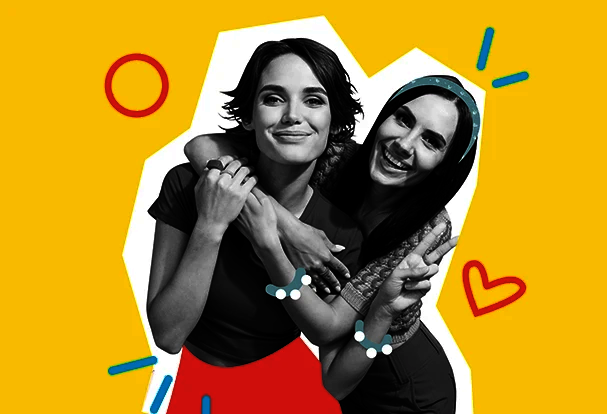 Valentinstag Fotogeschenke für Freunde: Zwei Freundinnen lachen und umarmen sich vor gelbem Hintergrund, modernes Motiv für persönliche Fotogeschenke zum Valentinstag.