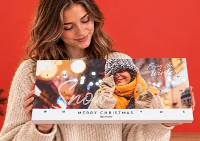 Frau hält personalisierten Foto-Adventskalender mit winterlichen Motiven